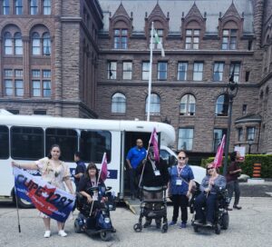 Union members carrying flags using walkers and mobility devices in front of parliament buildings